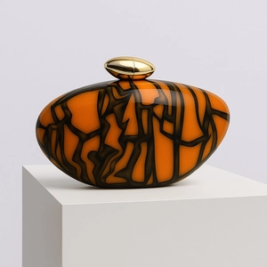 Elegant orange marble acrylic shell clutch bag with gold egg-shaped metal clasp on white stand