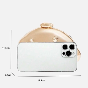 Gold oval evening clutch bag size reference next to smartphone, 17.5x11.5x7.5 cm