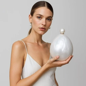 Elegant pearl shaped evening clutch bag with glossy finish and matching pearl earrings