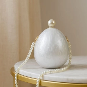 Detail of egg-shaped marble texture acrylic evening bag with oversized pearl clasp