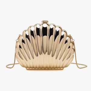 Detailed view of a semi-circular gold shell clutch bag with elegant pleated metal texture