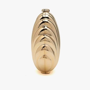Detailed close-up of golden semicircular evening clutch featuring tiered shell textures