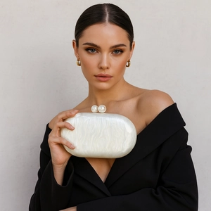 Detail of white acrylic clutch with pearl texture and large double bead clasp fastener