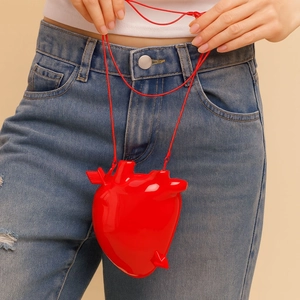 Glänzende, hellrote Schultertasche in anatomischer Herzform mit passendem Kordelriemen