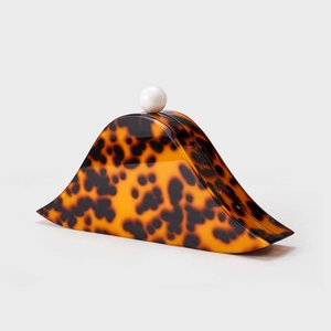 Macro shot of stylish tortoise shell acrylic evening clutch with white pearl clasp detail