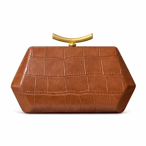 Detail of brown crocodile pattern handbag with elegant golden crescent metal handle