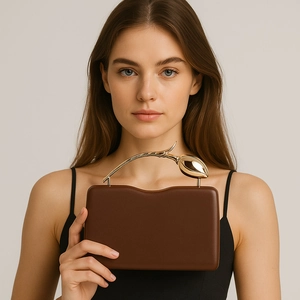 Detail of dark brown clutch bag with unique tulip-shaped gold metal handle for women