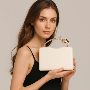 Detail of elegant cream PU evening clutch with golden tulip shaped metal handle