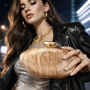 Fashionable acrylic marble texture clutch bag with gold clasp shown in urban night city