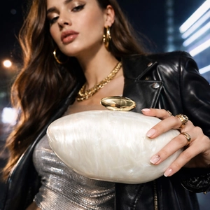 Elegant white marble acrylic evening clutch bag with gold clasp shown in urban setting