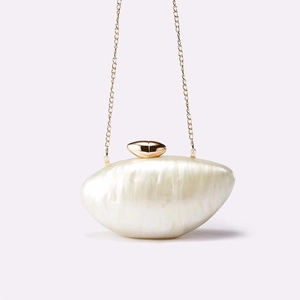 Close-up of mother-of-pearl texture acrylic evening clutch with gold metal chain strap