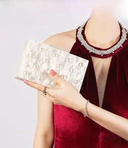 Detail der weißen Acryl-Abendtasche mit Perlenbesatz und gewellter Textur für Damen