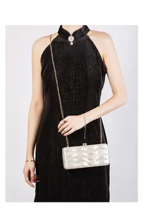 Chic pearlescent shell-textured acrylic clutch bag with a delicate gold chain strap
