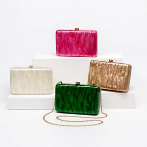 Vista dettagliata di quattro pochette in acrilico marmorizzato in rosa, bianco, oro e verde