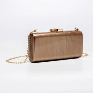 Detail of amber marble acrylic clutch bag with gold metallic clasp and chain strap