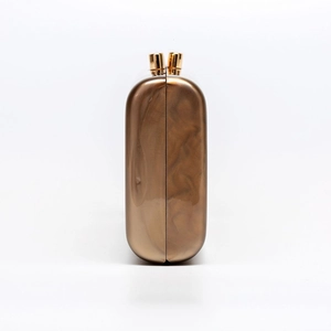 Detail view of brown marbled acrylic shell clutch with golden metal clasps for wedding