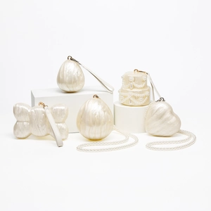 Detail of pearlescent white acrylic evening bags in seashell and heart shapes