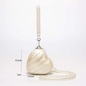 Macro detail of white heart-shaped acrylic shell clutch with pearl chain and dimensions