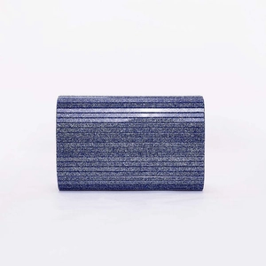 Detailed view of dark blue sequined evening clutch bag with striped glitter texture