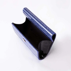 Detail of blue glitter acrylic evening clutch bag showing black interior lining and pocket
