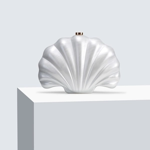 Detailed view of the pearlescent shell-shaped acrylic clutch with gold clasp for weddings