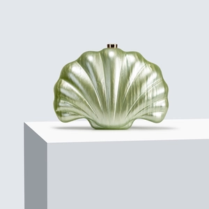 Close-up of pearlescent green shell-shaped acrylic evening clutch with gold metal clasp