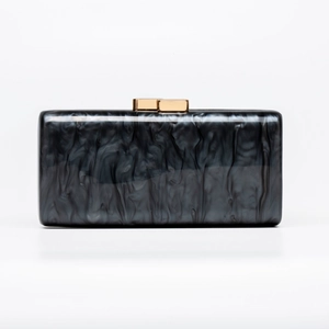 Detailed macro shot of rectangular acrylic evening clutch with gray marble texture and gold clasp