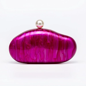 Detailed macro view of the fuchsia acrylic shell clutch with marble texture and pearl clasp