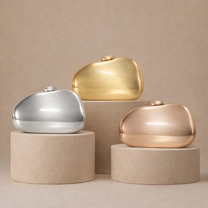 Three metallic clutch bags in gold, silver, and rose gold on minimalist podiums