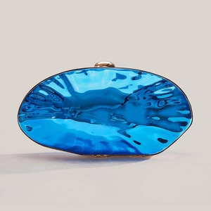 Metallic blue shell clutch bag with water ripple texture and golden clasp on white background