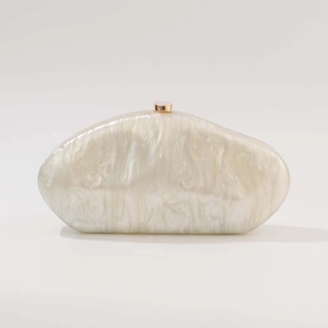 Detailed macro view of pearlescent marble acrylic evening clutch with rose gold clasp