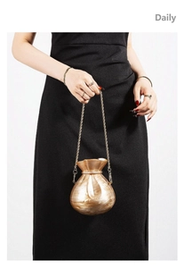 Detail view of champagne marble acrylic money bag clutch with elegant gold metal chain