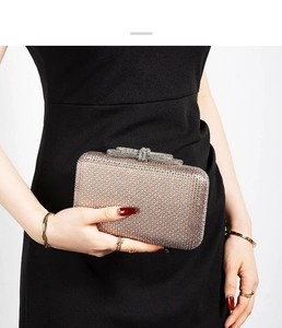 Close-up of sparkling rhinestone evening clutch with crystal bow clasp and metal frame