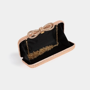 Detail of luxury rhinestone evening clutch bag with crystal bow and gold chain strap