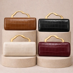 Detailed view of four colors of faux crocodile leather handbags with wave gold metal handles