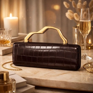 Close-up of brown croc-effect clutch bag with a unique gold handle and chain strap