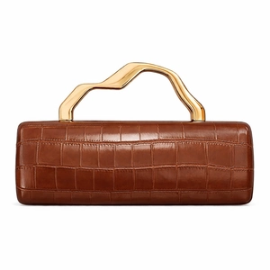 Detail of brown crocodile pattern clutch bag featuring unique gold curved metal handle