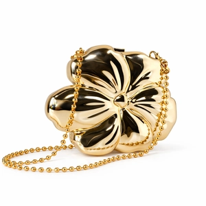 Makroaufnahme einer goldenen Blumen-Abendtasche mit polierter Oberfläche und Perlenkette