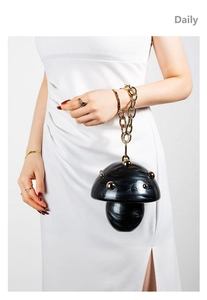 Macro shot of black marble acrylic mushroom bag with gold rivets and thick chain handle