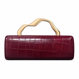 Close-up of burgundy crocodile pattern clutch bag with gold sculptural metal handle