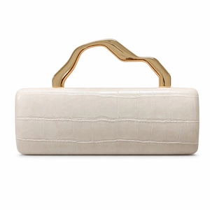 Detail of white crocodile pattern leather bag with artistic wavy gold metal handle