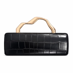 Close-up of black crocodile pattern evening clutch with stylish gold wave handle