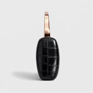 Side view of black crocodile pattern leather evening bag with rose gold metal handle