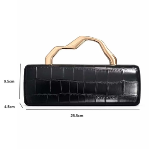 Detail view of black crocodile pattern evening bag with golden geometric handle and dimensions