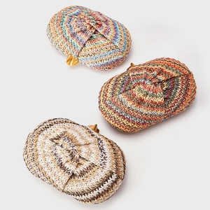 Three semi-circular woven straw clutch bags with gold metal clasps in a 45-degree view