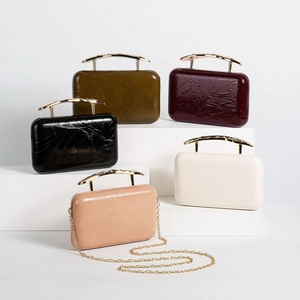 Close-up of five pleated PU leather evening bags with curved gold handles and chain straps