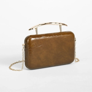 Detail of vintage brown textured PU leather evening bag with golden metallic top handle