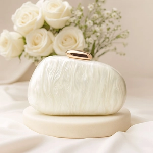 Detailed view of white marble acrylic evening bag with a gold pebble-shaped clasp