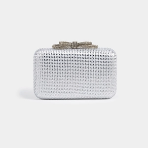 Close-up of a silver rectangle clutch with sparkling rhinestones and a bow clasp