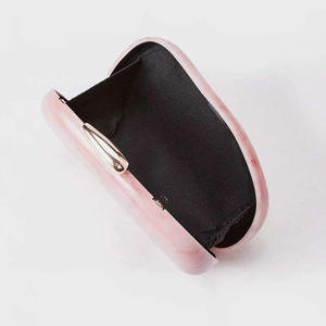 Detailed view of pink marble acrylic evening clutch with gold clasp and black lining